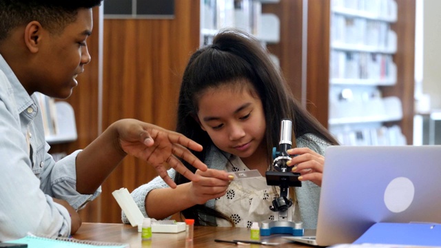 导师教女学生如何使用显微镜视频素材