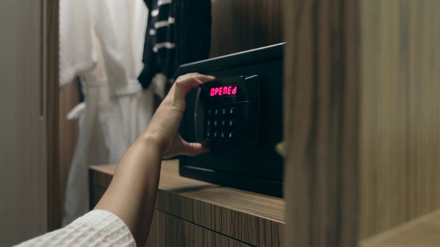 女人双手打开保险箱的组合在酒店房间视频素材