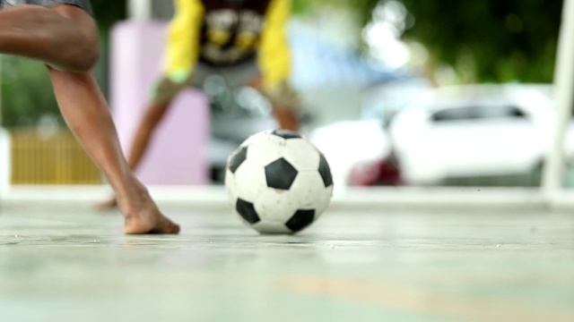 在泰国的一个村庄里，农村的孩子们正在踢足球，慢镜头，散焦视频素材