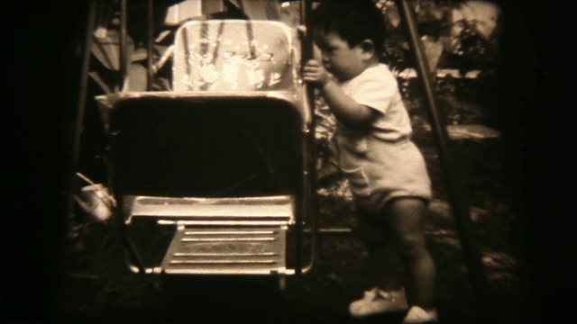 60年代的8毫米镜头-小男孩玩秋千视频素材