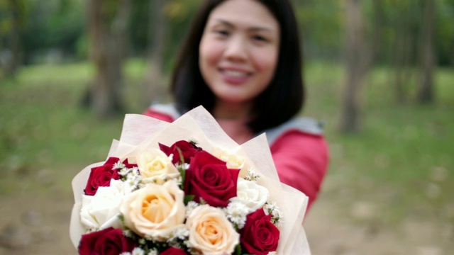 女人捧着红白花，情人概念，慢镜头视频素材