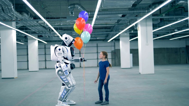 一个小女孩送气球给机器人的空仓库视频素材