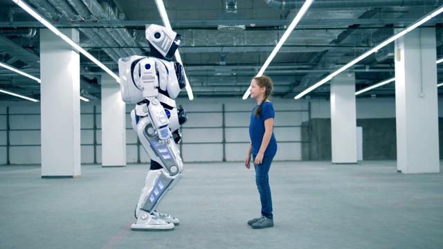 一个女孩和一个机器人正在触摸对方的手掌视频素材
