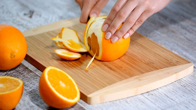 用木砧板去皮橙子。视频素材