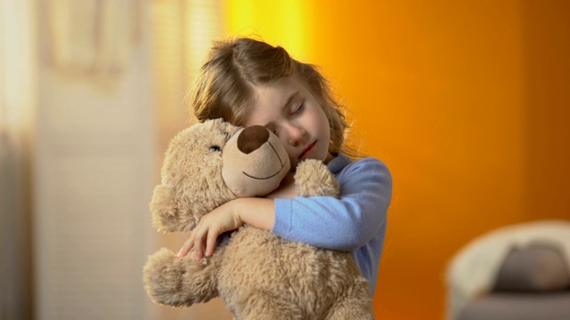 孤独的小女孩拥抱泰迪熊，忍受孤独，家庭问题视频素材