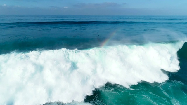 巨大的蓝色海浪撞击在阳光明媚的一天的慢镜头鸟瞰图视频素材