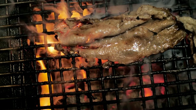 烧烤牛排在烤架上慢动作视频素材