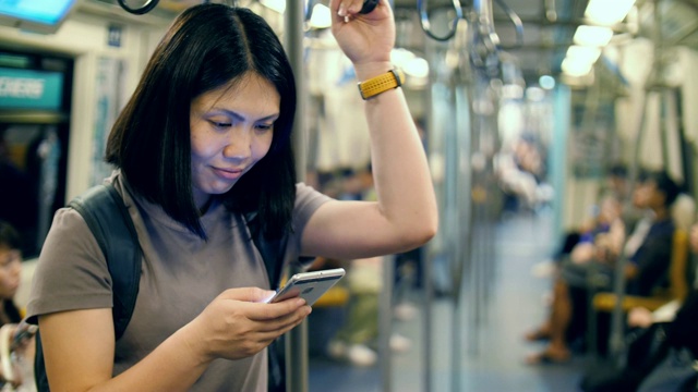 女性在地铁上使用智能手机视频素材
