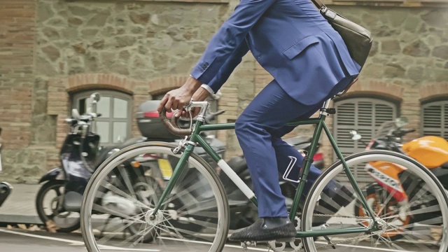 中间部分是商人在城市里骑自行车的慢动作视频视频素材