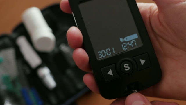 在血糖仪、血糖仪中插入测量血糖水平条视频素材