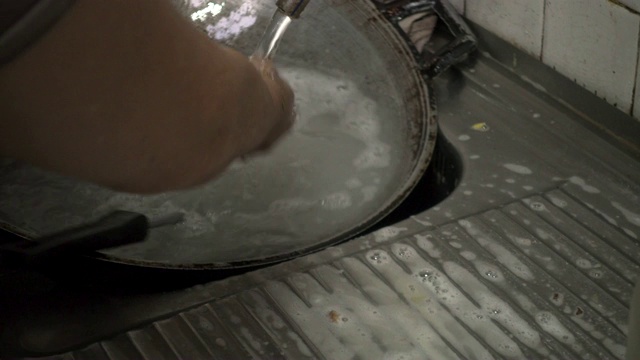 老女人在家里用手洗盘子。视频素材