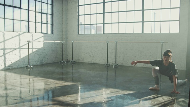 自信的芭蕾舞演员在明亮的工作室跳舞视频素材