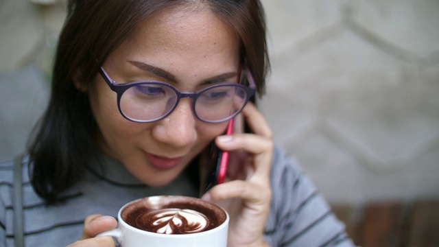 一个在咖啡店用手机待命的女人视频素材