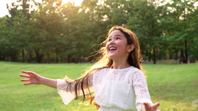亚洲小女孩玩气球在公园背景日落视频下载