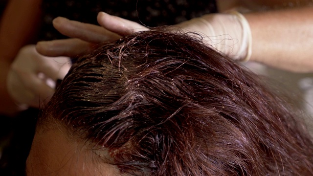 头发,美丽、虚荣。在女人头上涂染发剂视频下载