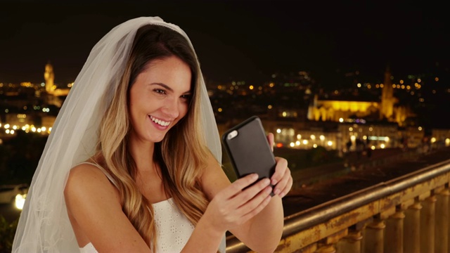 在佛罗伦萨美丽的夜晚，快乐的新娘在自拍视频下载