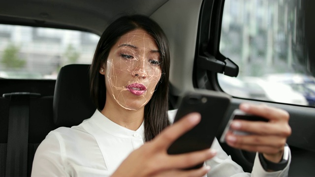 商务女性在车中使用面部识别技术解锁智能手机并支付视频下载