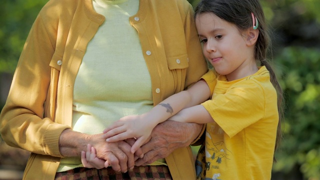 援助之手。一个孩子的手牵着高级妇女的手的细节视频素材
