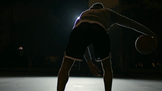 活跃的男子运动员在晚上运球视频下载