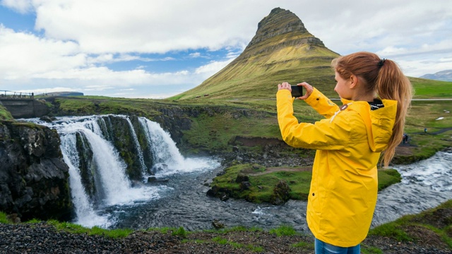 女游客拍摄冰岛风景优美的照片，kirkjufelsfoss瀑布和山kirkjufalls在Snaefellsnes半岛视频素材