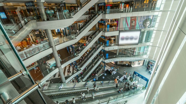 4K时间推移过渡倾斜下来的自动扶梯和拥挤的匿名的人在购物中心快速移动，购物中心和旅行的生活方式视频下载