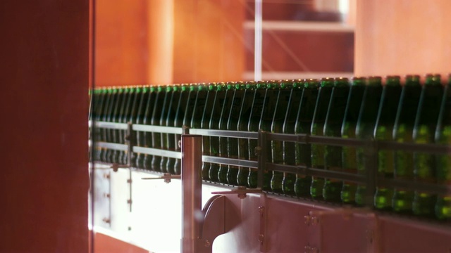 工厂啤酒生产线。带着酒瓶的传送带的特写视频素材