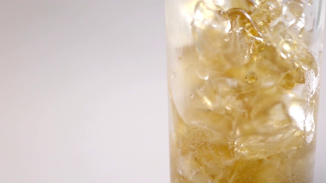 近距离的可乐倒进玻璃与冰的慢动作视频素材