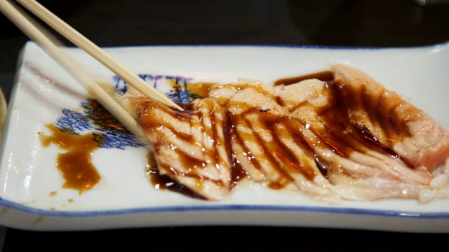 近距离用筷子挑烧在白色盘子上的鲑鱼。日本融合食物，亚洲文化。健康食品，饮食概念。视频素材