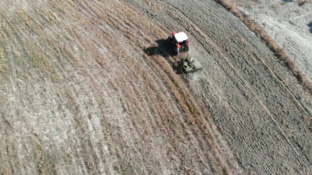 鸟瞰图拖拉机在农村犁地。克罗托内,卡拉布里亚视频下载