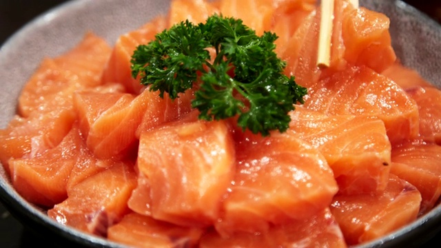 近距离用筷子挑大碗上的一组鲑鱼。日本融合食物，亚洲文化。健康食品，饮食概念。视频下载