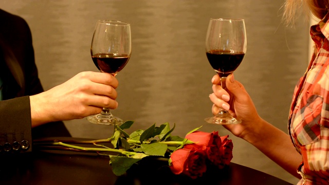 男人和女人用红玫瑰花酒杯敬酒视频素材