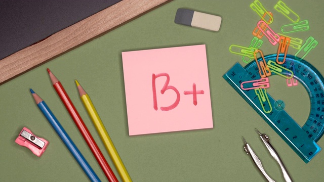 近距离观看女人的手写B +标记在sticky记事本。视频素材