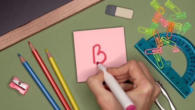 学校的概念。女人在便利贴上写B- (B + -)。视频素材