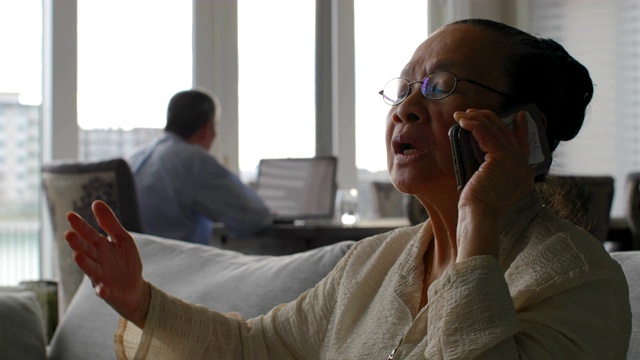 前视图老资深亚洲妇女在一个舒适的家讲手机4k视频下载
