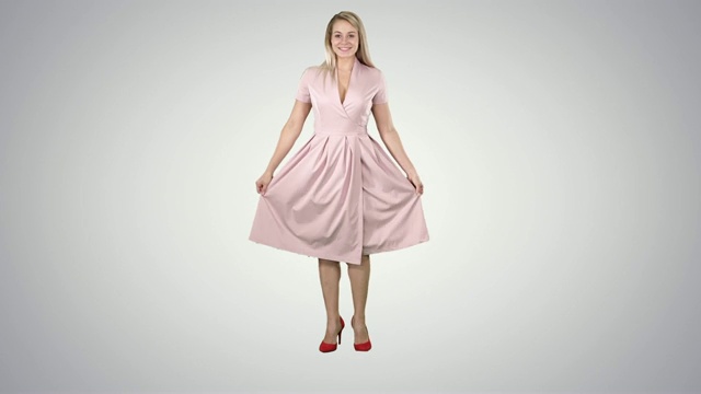 一个穿着粉红色裙子的女人转过身来看着自己，就像在渐变背景的镜子里一样视频下载