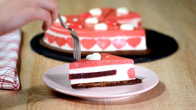 一块红莓慕斯蛋糕放在盘子里。美丽的装饰心形慕斯蛋糕，在情人节。视频素材