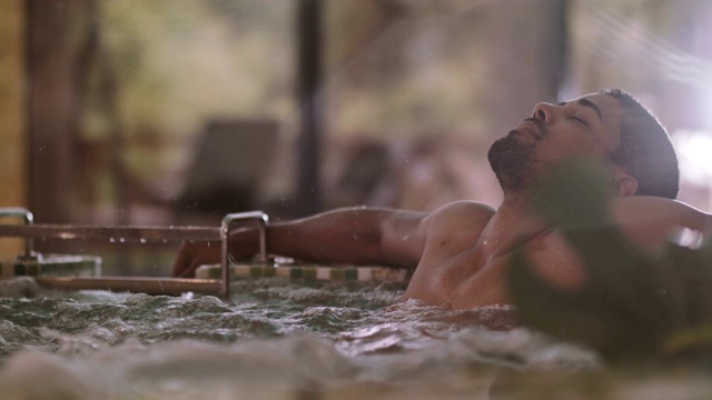 在温泉浴池里放松的男人视频素材