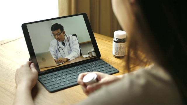 白人女性用平板电脑视频呼叫亚洲男性医生视频素材
