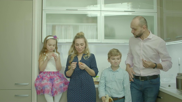 快乐的父母和兄弟姐妹在厨房分享水果视频素材