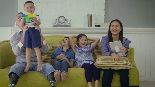 幸福的家庭在家里客厅的沙发上一起放松和看电视视频素材