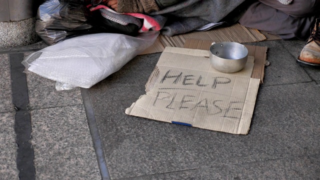 一个穿着脏衣服睡在街上寻求帮助的无家可归的老人视频素材
