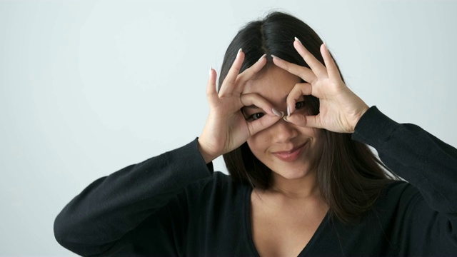 女人用双手捂着眼睛，做出ok的姿势视频素材