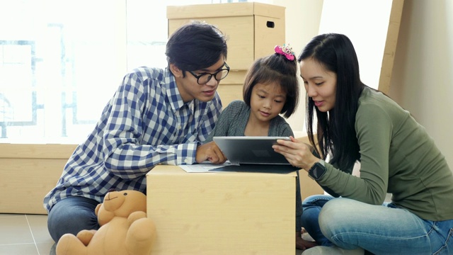 一家人搬新家，用写字板和孩子装饰房子，慢镜头视频素材