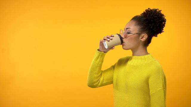 戴眼镜的黑人女孩喝着恶心的咖啡，味道难闻视频素材