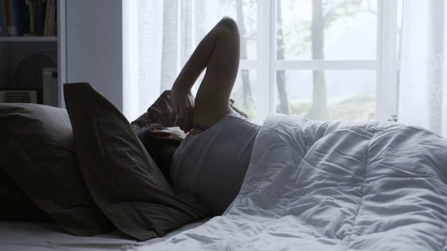 快乐的女人在床上醒来视频素材