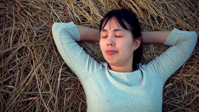 睡在稻田稻草上的妇女视频素材