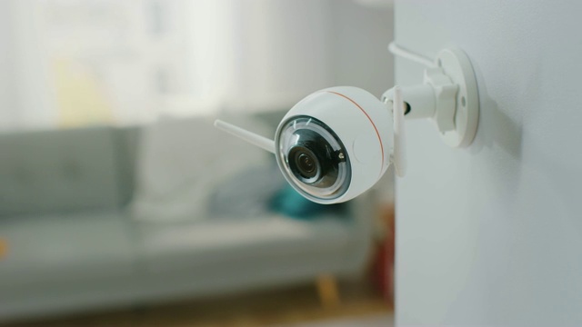 近距离物体拍摄的现代Wi-Fi监控摄像头与两个天线在一个舒适的公寓的白墙上。视频下载