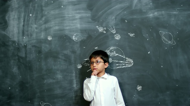 男孩在黑板上用动画行星思考视频素材