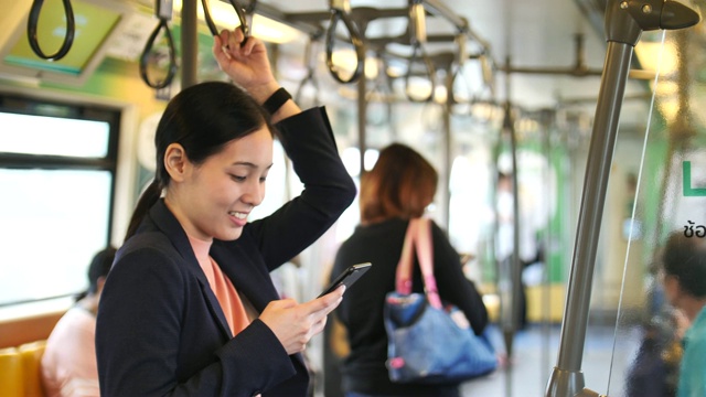 年轻的亚洲女子在地铁里使用智能手机视频素材