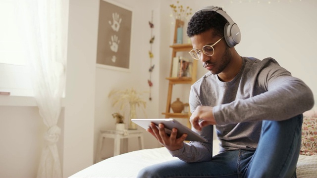 男人一边听音乐一边使用数码平板电脑视频下载